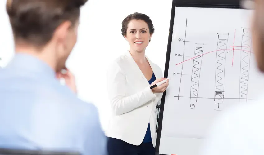 smiling-businesswoman-presenting-chart-audience
